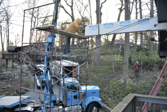 The worker on the staging moved the strap from the center of the beam to the end closest to the crane.