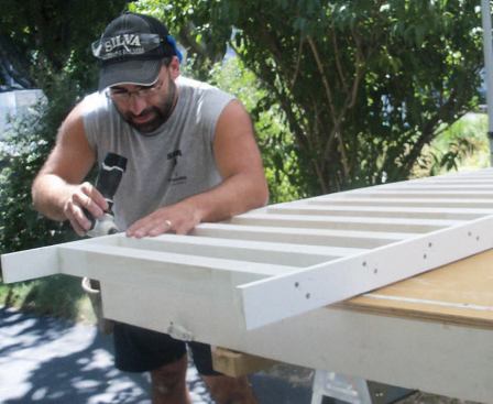 Preprimed wood balusters were fastened to PVC spacers to create assemblies that fit between the top and bottom rails.