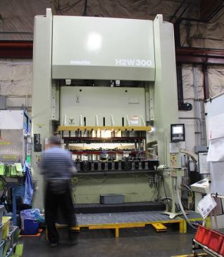 This giant machine is a progressive punch press, which performs multiple operations to the same piece of metal. The first time the dies come down they might form a particular shape. The next time they come down they might punch a few holes, fold the edges, or punch the piece out. The dies for this thing were massive, a series of pieces bolted onto a pair of steel slabs about 2” thick by 2’ wide by 7’ long. I’d show you a picture but dies are the one thing in the factory I was not permitted to photograph.