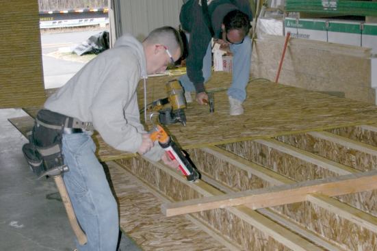 A simple 2x4 jig helps to keep floor joists aligned as floor sheathing is placed and fastened.
