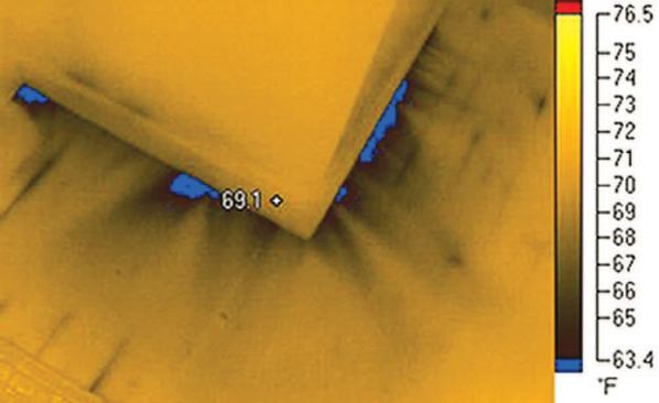 Depressurizing a structure with a blower door reveals characteristic "fingers" of infiltrating outside air, as can be seen underneath this baseboard.