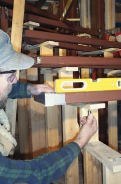 He fine-tunes the height of the frame by turning threaded bolts in the stage.