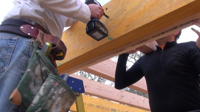 Hill drives a countersunk FastenMaster structural screw to make the connection between the Doug Fir joists and the LVL main beam. Later, the connection will be beefed up with a Simpson joist hanger.