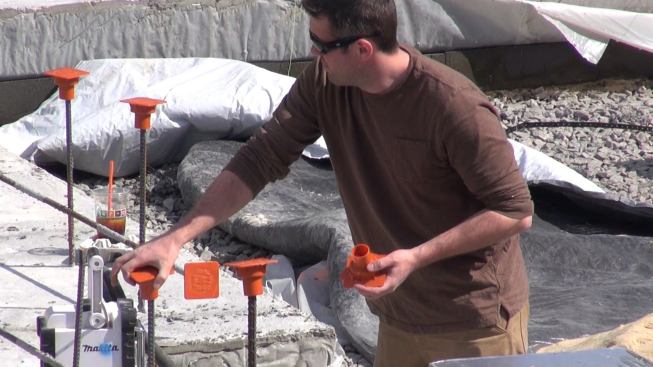 Auburndale carpenter Casey installs protective safety caps on the rebar projecting from the building’s perimeter footing.