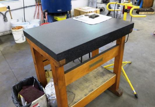 This top of this table is a granite surface plate and is as flat as flat can be. Planes and other tools can be placed on this surface and checked for accuracy (flat, straight, square, etc.)