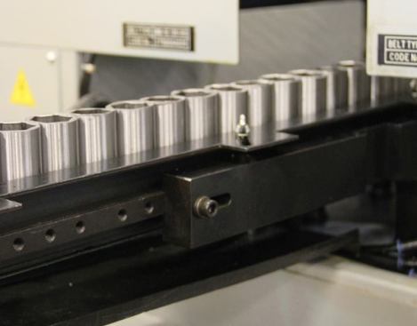 Sockets are being fed into a computer-controlled machine that will smooth sharp edges and slightly chamfer the openings. The chamfer makes it easier to fit the stem of the ratchet into the socket and the end of the socket over a bolt.