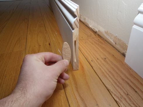 If a wall is longer than our baseboard stock, we splice sections together with biscuit-reinforced butt joints before setting the sections of baseboard in place to test the fit.