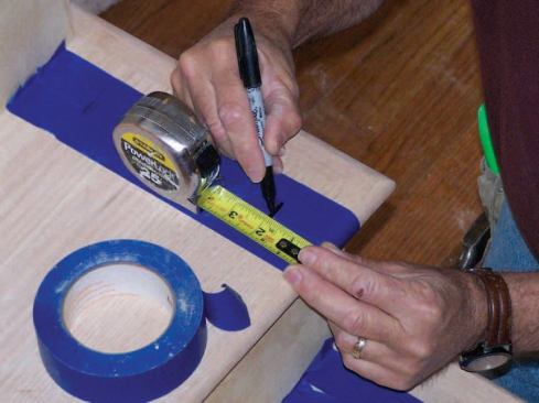 Double widths of masking tape protect the treads; the baluster locations go right on the tape.