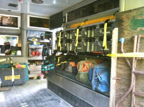 As originally configured, there was a padded bench along the right side of the module. The cushion is now being used as a platform for a series of soft tool bags. This area can no longer be used as seating because the author installed a shelf above it - shown here with multiple Husky tool boxes strapped in from the side.