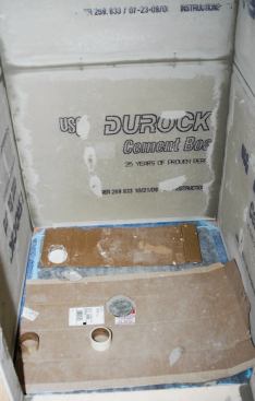 I used cardboard to protect the shower base and also to create a gap at the bottom of the cement board.
