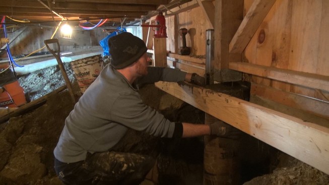 Chris checks the plumbness of the newly placed Sonotube with a four-foot level.
