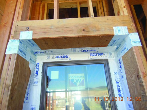 Next, the top corners of the recess are flashed, and a head flashing is installed over the window flange.