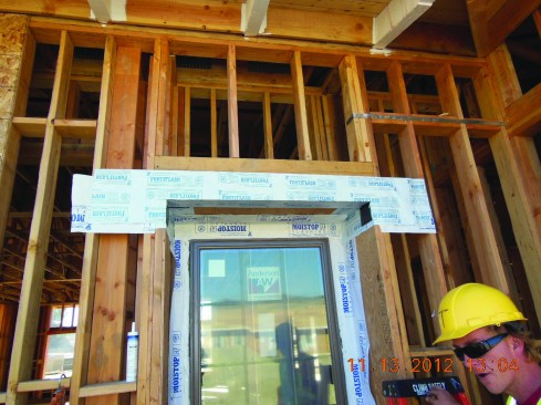 The final step is to apply a flashing membrane on the exterior face at the top of the opening. This piece of flashing is slit at the edges of the opening and folded back over the top edge of the recess.
