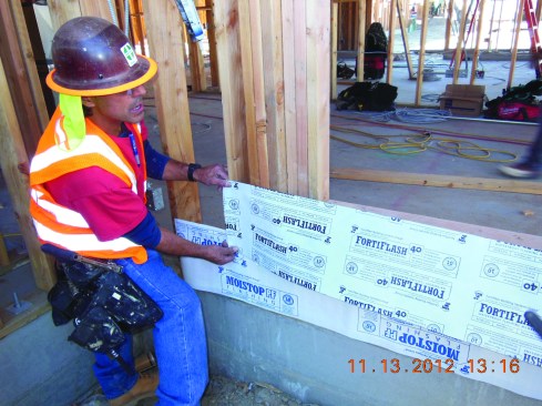 Apply sill flashing across the exterior face of the wall framing.