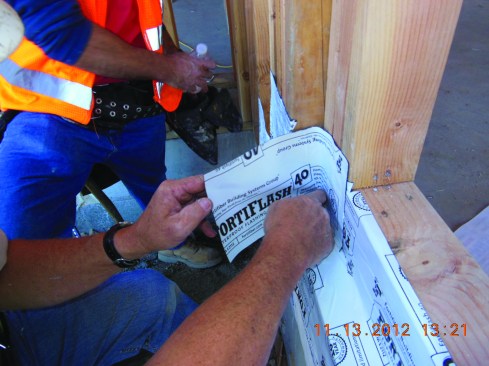 Cut short pieces of flashing membrane to create end dams on both sides of the recessed opening. Here, the end dam pieces are bedded in caulk before the installer rolls the edges.