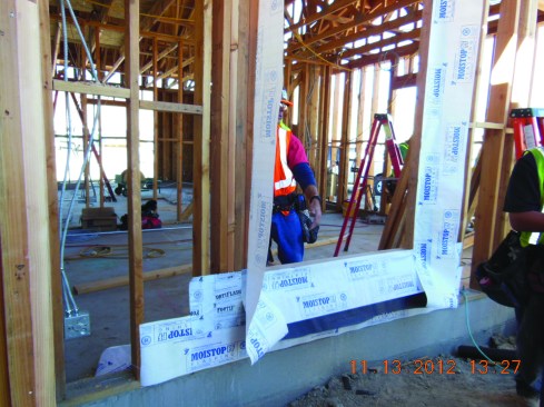 With the side flashings in place, the window unit can be installed. (To meet the window manufacturer’s requirements, the window flange must be installed in a bed of sealant; see “Installing Flanged Windows,” Jan/16.)