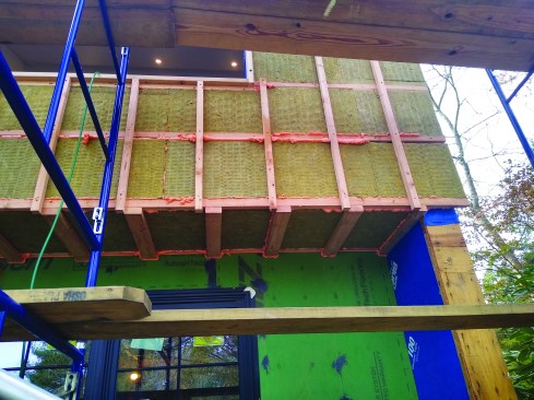 A grid of horizontal strapping followed by vertical strapping was filled with Comfortboard 80. Canned spray foam was used to fill any small voids, reducing convection and slowing vapor movement within the assembly.