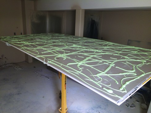 He hung a second layer of ceiling drywall, using two quartsize tubes of Green Glue per sheet. The product is not an adhesive but a sound-absorbing layer that evens out to a 1/8-inch-thick layer when the second sheet of drywall is pressed into place with a drywall lift.