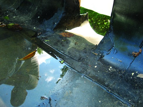 Properly flashed-in scuppers have several layers. The flashing itself can create a dam.