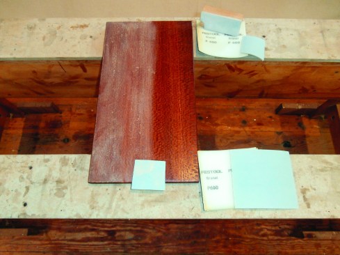 While preparing sample boards, the author sands between coats of clear finish with foam-back 400- and 600-grit pads (the ones above are from Festool).