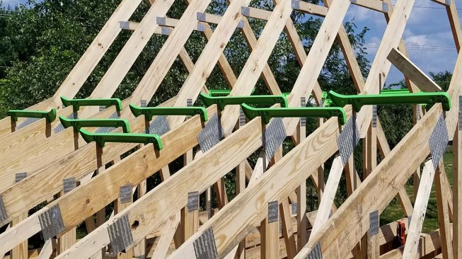 The grab end slips over the preceding truss and locks them together.