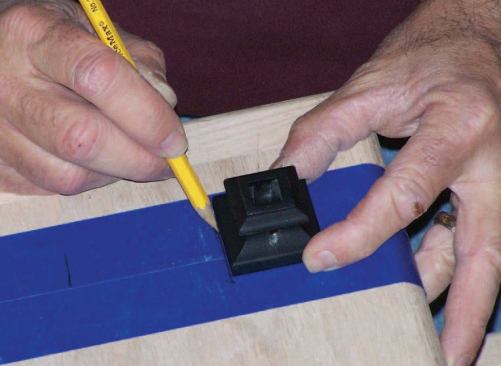 To lay out the hole positions on each tread, I use the metal shoe that the balusters fit into as a template.