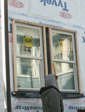 In order to secure the deep exterior jambs needed to cover the double layer of foam, carpenters fastened 2-by blocking around the windows directly against the housewrap.