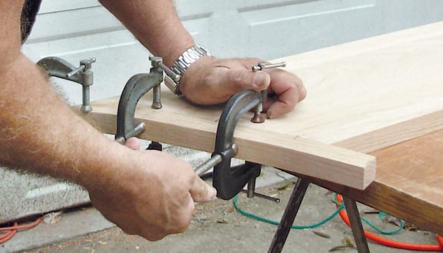 Glue on the Return, Install: After checking the fit, I apply glue to the first 3 inches of both the tread and the return, then clamp the joint together.