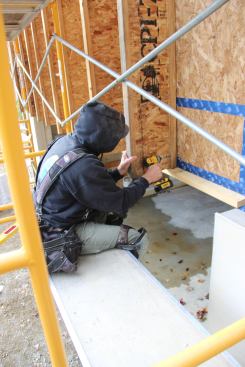 Wood I-joists are fastened through sheathing to the inner stud wall through tape-sealed OSB sheathing using GRK RSS structural screws.