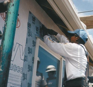 The crew slid the top flange under the Tyvek and sealed the flange to the Tyvek all around the window.