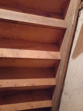 The carriage is about as simple as they come. On the wall, a 1-inch apron is nailed to the wall, and the 1-inch stringer is nailed to that. Treads and risers are also 1-inch thick. All of the wood is quarter-sawn oak and that is the secret to the stair's strength and longevity.