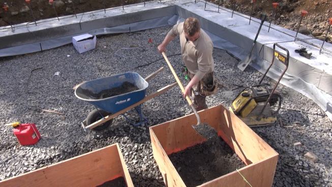 Tim shovels crusher run into a form.