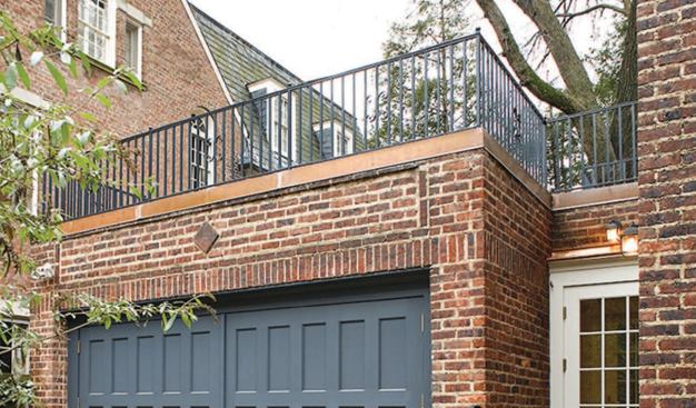 New copper flashing fitted around an iron deck railing serves as a waterproof cap over the parapet.