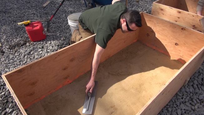 Troweling the sand smooth and flat.