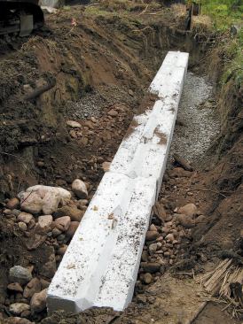 He leveled the trench bottoms with stone fill and gravel, then placed a series of interlocking precast blocks.