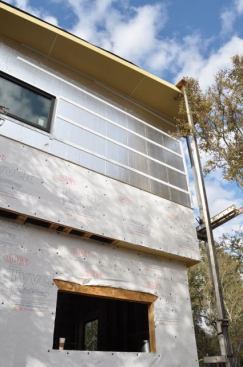 We used Tyvek DrainWrap on the walls, then covered them with 3/4-inch R-mate foam that has a silver facing for additional radiant barrier. Notice the horizontal rainscreen for the vertical wood siding on the front of the house.