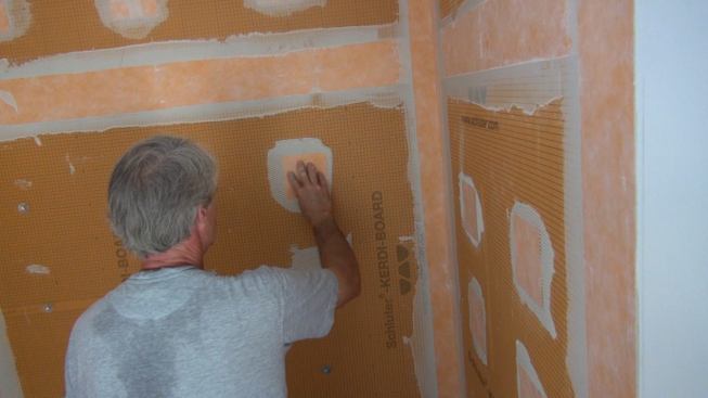 Boucher applies a square patch of Kerdi-Band into the mortar at the screw penetration.