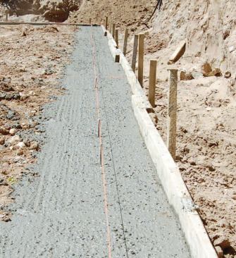 Although wood foundations have traditionally been supported by footings of carefully compacted gravel or crushed stone, a poured concrete strip footing can also be used.