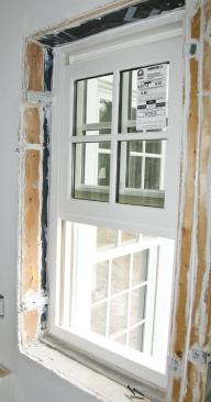 Window sealing was time-consuming, with caulk outlining the metal installation straps and the interior edges of the self-adhering window flashing.