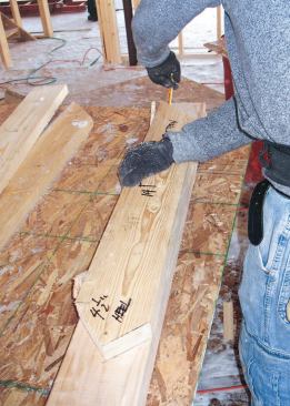 Rafters: Though the construction drawings showed curved rafter tails cut out of full-dimension 2x12s, I decided that framing the roof with straight rafters and building up the curved profile with horizontal blocking would be easier and provide better nailing for the bent sheathing. We made a rafter pattern out of 2x6 stock and cut the first pair of rafters.
