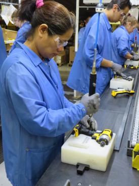 The gal in the foreground uses a 
pneumatic screwdriver to join the two halves of an impact driver’s case. A similar process is used on the drills and recip saws assembled at the plant.