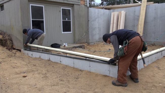 Hill and Horgan set the sill plate into place onto the foundation sill.