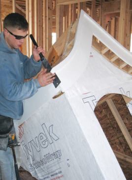 Countdown: While the dormer was still inside, we trimmed out the gables and eaves with Azek, then sheathed the roof with 3/ 8-inch CDX plywood. We first hand-nailed to get the sheathing to conform to the curve, then finished up with staples. To make it easier to nail the valley plates to the roof deck, we left a couple of small sections of the sheathing tacked.