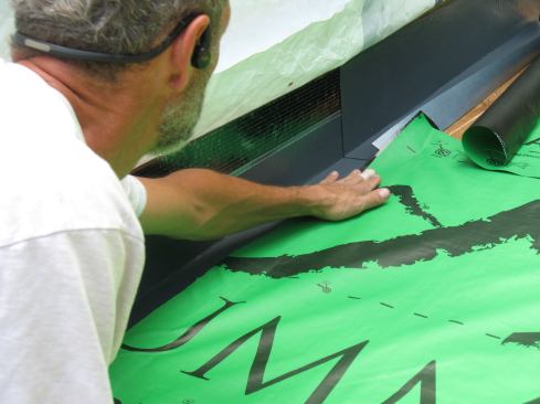 The remaining 2-inch portion of the flashing tape folds over on itself and bonds to the roof underlayment. The joined pieces then fold toward the wall.