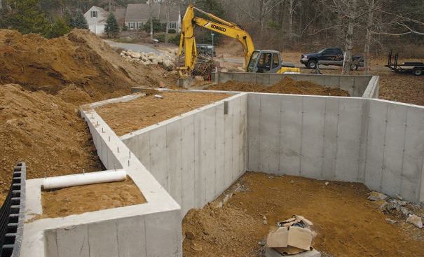 The finished compartments were filled with compacted soil and later capped with concrete slabs, providing a code-required setback from the septic system’s leaching field.