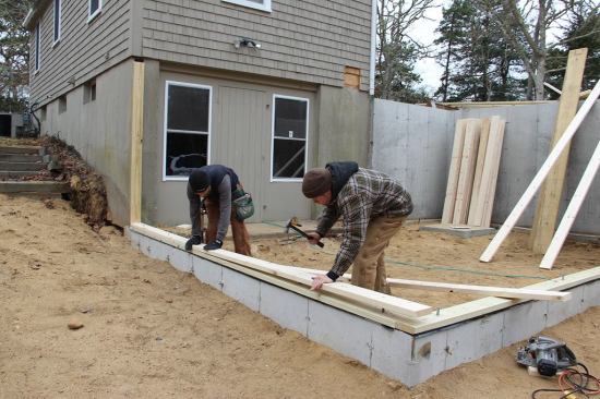 Hill and Laffin test-fit the bottom plate for the new wall.