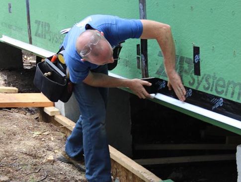 Sealing Z-flashing to the bottom of the ZIP wall system using ZIP tape.