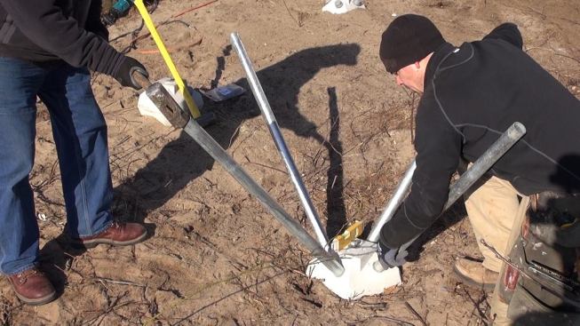 With the concrete hub in position, a sledgehammer serves to start the process of driving the pins into the subsoil.