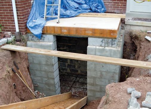 The block foundation of the small addition includes a shelf for the new brick veneer. After the deck was framed and the new masonry walls stabilized, a new precast bulkhead was craned into place.