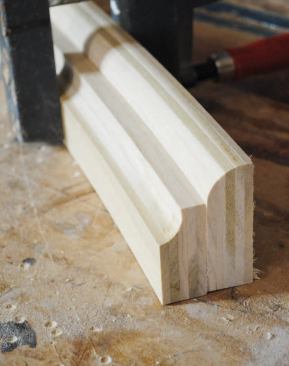 I then profiled the blanks separately and combined them to make one large piece of trim. The flat top cap measures about 5/16 inch thick and has a square edge, while the other two laminations measure about 13/16 inch thick. I cut the profile on the middle section with a 3/4-inch roundover bit and used a 5/8-inch cove bit to cut the profile on the lower section.